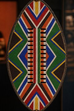 Traditional Zulu shield with vibrant, symmetrical beadwork, cultural artifact.