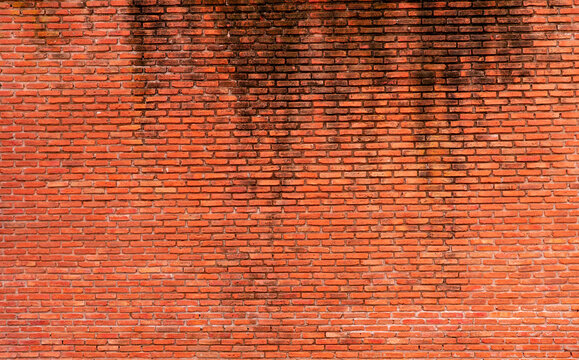 Weathered red brick wall texture with aged masonry pattern, detailed construction background featuring rustic building materials, distressed surface, architectural facade and seamless urban copy space