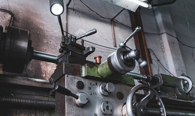 Old lathe machine in factory. Lathe turning machine for metalwork. Heavy machinery manufacturing. Machine for milling metal. Manual lathe machine. Safety in industrial workplace. Steel industry. © Fahroni