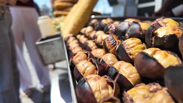 People enjoy roasted chestnuts at a market in a city