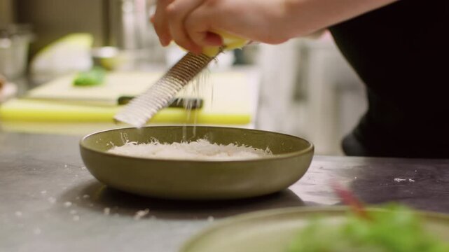 Dairy meal. Food preparation. Unrecognizable professional chef man hands making presentation cooking parmesan cheese salad dish on plate in restaurant.