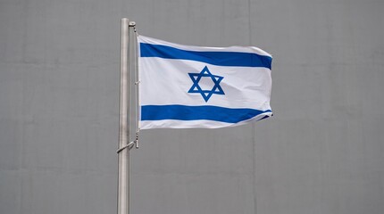 Fototapeta premium Israeli flag waves proudly, blue stripes and Star of David symbolize national identity, heritage, and unity against cloudy sky backdrop.