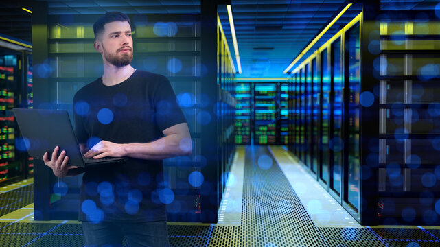 Data center. IT specialist monitors server infrastructure with a laptop, managing network operations, cybersecurity, system performance and cloud computing services.