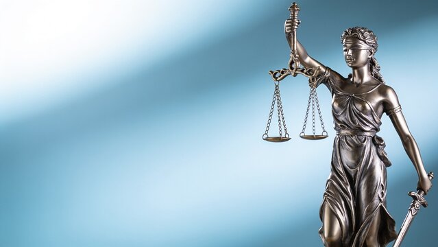 Lady Justice statue holding scales and sword on abstract blue background with copy space, law and legal concept