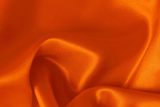 Orange fabric cloth texture for background and design art work, beautiful crumpled pattern of silk or linen.