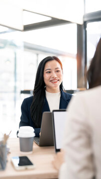 Asian businesswoman smiling during professional job interview or business meeting in office