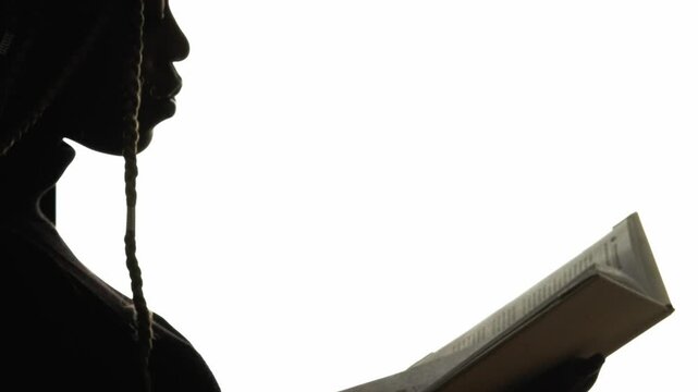 Student silhouette. Knowledge education. Profile of smart woman reading book learning isolated on white empty space background.