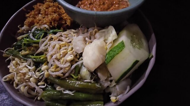 rice with vegetables,Pecel is vegetables salad with spicy peanut sauce,traditional food from Java IndonesiaDelicious noodles mixed with greens and spices. Served with a small bowl of peanut sauce