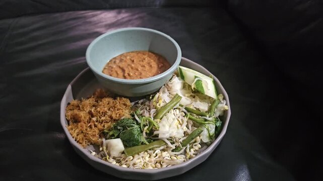 spices and herbs,Pecel is vegetables salad with spicy peanut sauce,traditional food from Java IndonesiaDelicious noodles mixed with greens and spices. Served with a small bowl of peanut dipping sauce.