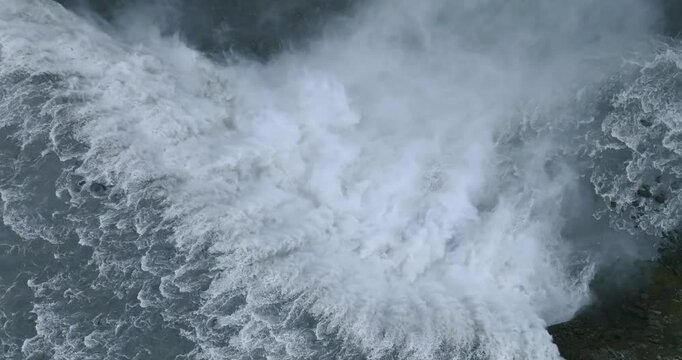 Dettifoss Waterfall thunders into Jokulsargljufur Canyon as dense mist rises above the Jokulsa a Fjollum, revealing powerful glacial whitewater and rugged basalt cliffs super slow motion aerial ascent