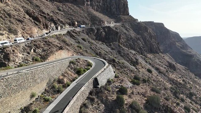 Aerial panorama flight along road over viewpoint Mirador Degollada de las Yeguas towards Maspalomas and Atlantic Ocean on Canary Island Gran Canaria, Spain