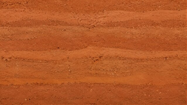 Rammed earth texture showing layered red clay soil