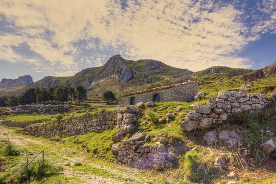 Traditional farmhouse surrounded by stone walls in a hilly landscape, near Novara di Sicilia, Sicily, Italy