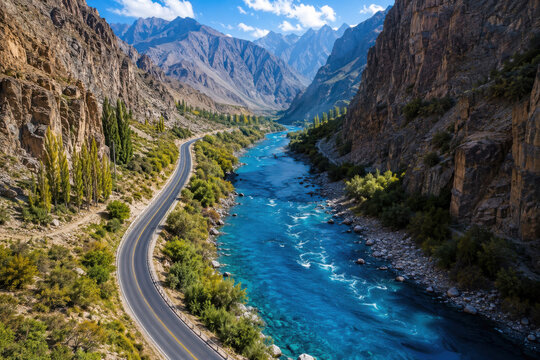 Winding road along a blue river in a deep mountain canyon valley