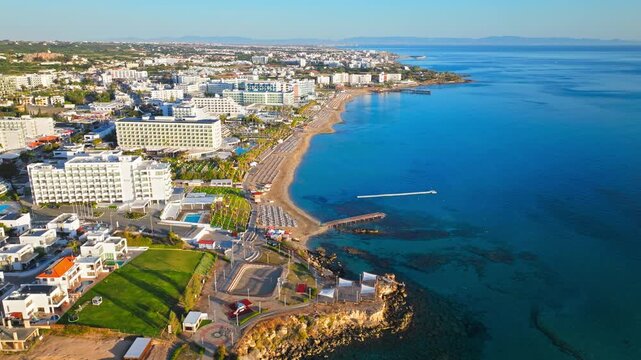 Aerial view of Protaras coastline in Cyprus. Rocky shore, turquoise water and white resort buildings create a scenic coastal panorama.