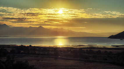 Fototapeta premium sunrise over Skadar Lake National Park and misty mountains, Virpazar, Montenegro