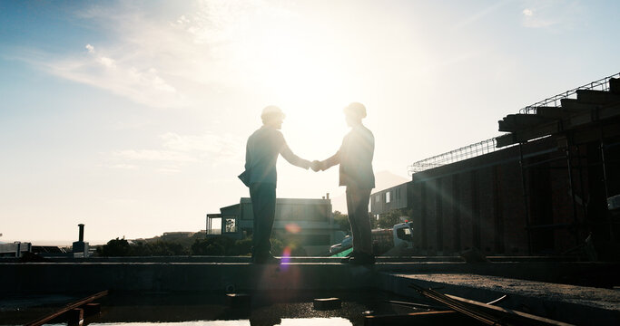 Construction, silhouette or men on rooftop with handshake, greeting or deal in building project. Space, flare or engineer with shaking hands, partnership agreement or approval in industrial expansion