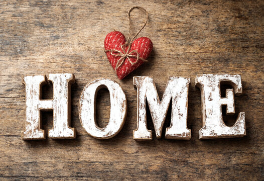 Rustic wooden letters spelling home with a red heart decoration on top for cozy decor
