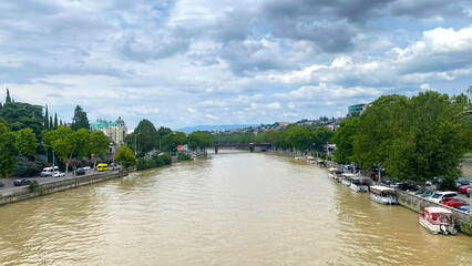 Kura River flows through central Tbilisi beside the Peace Bridge, connecting embankment roads, tour boats © chekart