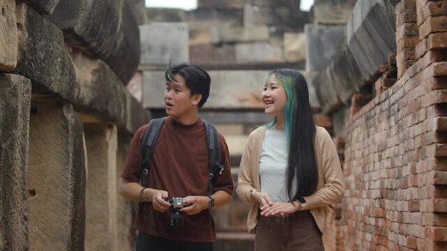 Young Asian Travelers Exploring Ancient Stone Ruins and Historic Architecture During Cultural Heritage Tour