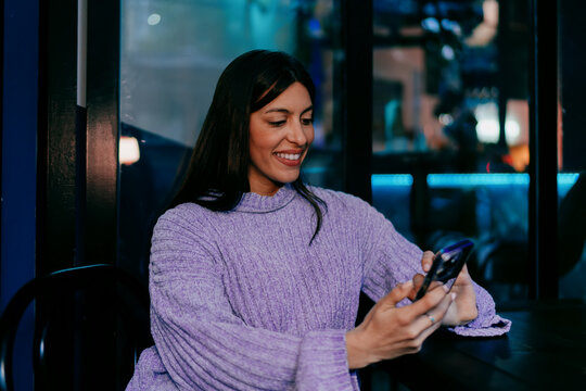 Smiling female user typing on digital tablet with stylus in hand. Financial technology, online banking, data processing or creative editing. Modern professional working in wooden textured office.
