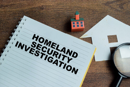 Concept of homeland security investigation write on book isolated on Wooden Table.