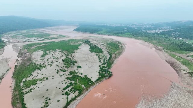 Aerial view of massive silt and muddy waters during Jammu floods, showing the altered flow of the Tawi River in monsoon season.