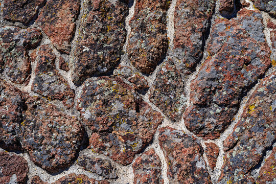 Abstract patterns of lichen covered rocks cemented into an exterior wall