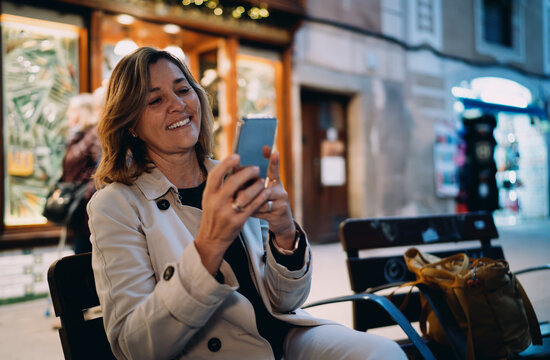 Happy woman with smartphone sitting city bench, Caucasian lady browsing mobile application outdoor, copy space, digital communication technology, online banking shopping, 5G internet, social media