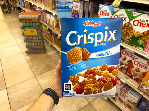 Shopper Holding Kellogg's Crispix Cereal Box in Aisle