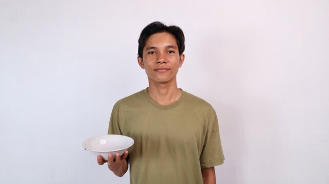 young asian man holding empty bowl