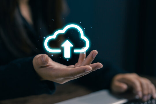 Businesswoman presenting a glowing cloud upload icon, symbolizing cloud computing, online storage, data backup, file synchronization, digital infrastructure, and secure technology.