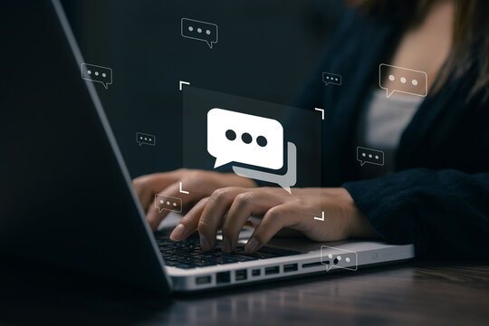 Businesswoman typing on a laptop with virtual chat icons, illustrating online communication, customer support, business messaging, digital collaboration, and remote communication.