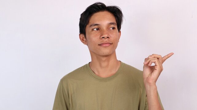 young asian man pointing and glancing sideways