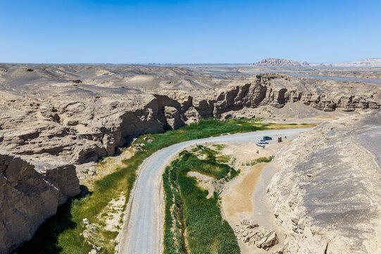 Aerial view of a winding road through a green canyon oasis in the desert, Dahaidao, Xinjiang, China