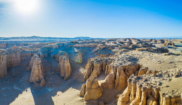 Aerial view of eroded yardang landforms with dry clay pillars and sunbeams in Dahaidao, Gobi Desert, Xinjiang, China