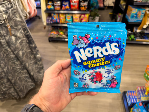 Hand Holding Nerds Gummy Clusters Candy Bag In Store