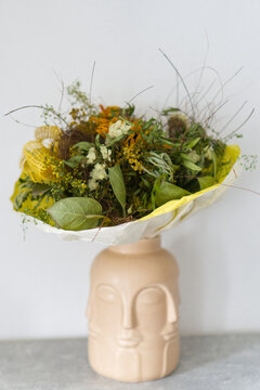 Bouquet of dried flowers in an original ceramic face vase