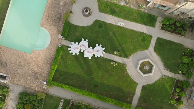 Aerial View of Garden Outdoor Wedding Reception With Pool, Fountain and Tables Set for Celebration