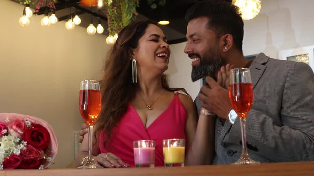 Romantic indian couple celebrating special moments or wedding anniversary in restaurant with candle light and flowers, Love and bonding, Valentines day.