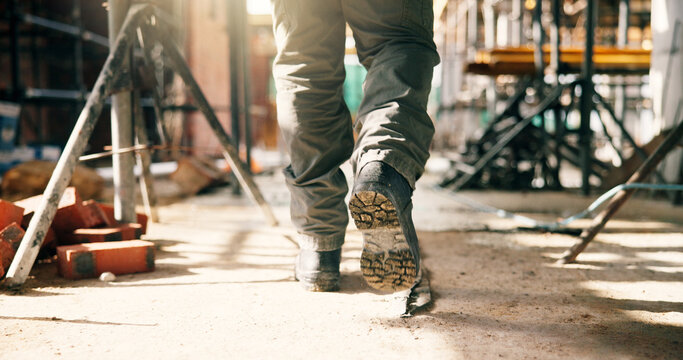 Boots, person and walking at construction site for renovation, contractor and inspection of building progress. Foreman, engineering and shoes for remodel, infrastructure upgrade or project management