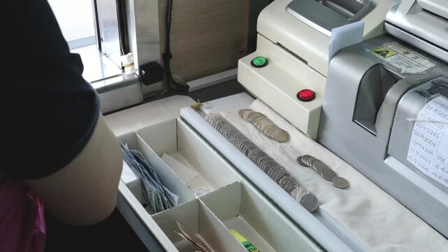 톨게이트 요금 징수원이 부스 안에서 카드를 받고 정산하는 모습입니다.