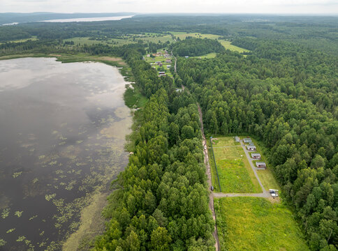 Aerial view of a small holiday resort and sub-divided land plots by a quiet forest lake on an overcast summer day in Karelia, Russia