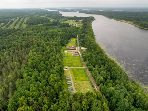 Aerial view of a small holiday resort and sub-divided land plots by a quiet forest lake on an overcast summer day in Karelia, Russia