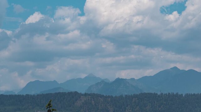 4K Time lapse shot of clouds above the Himalayan mountain range of Parvati Valley in Himachal Pradesh, India. Scenic view of mountain range during the summer season with clouds. Scenic background.