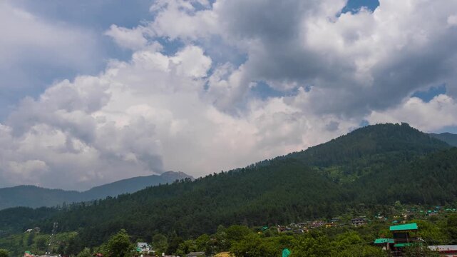 4K Time Lapse shots of clouds above the green Pine tree forest on a Himalayan mountain during the monsoon season as seen from Naggar in Himachal Pradesh, India. Monsoon background with copy space.