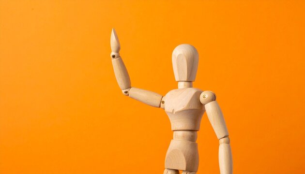 Wooden Artist Mannequin Raising One Hand in a Waving Gesture Standing Against a Bright Orange Background
