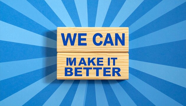 Two Wooden Blocks Displaying We Can Make It Better Text Stacked Against a Blue Radial Sunburst Background