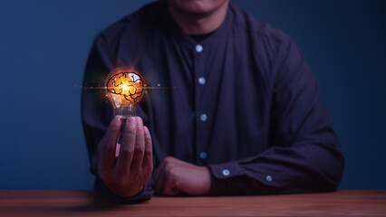 Man holding a glowing light bulb with a brain inside. This concept illustrates artificial intelligence, smart business innovation, human creativity, technology, and brilliant mind ideas. © ParinPIX