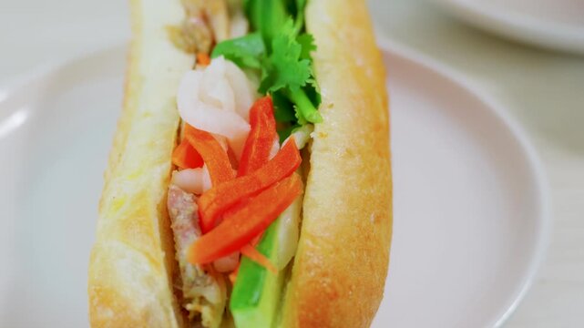 Close up of fresh Vietnamese banh mi sandwich with cucumber and carrot